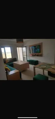 a living room with a couch and a table and chairs at Cosy appartement in Oulad Akkou