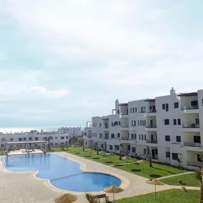 a large apartment building with a large swimming pool at Cosy appartement in Oulad Akkou
