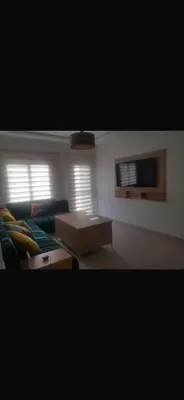 a living room with a couch and a table at Cosy appartement in Oulad Akkou