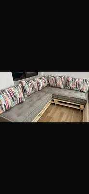 a grey couch with colorful pillows on it at Cosy appartement in Oulad Akkou