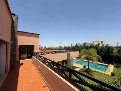 a balcony of a house with a swimming pool at Villa Denalya in Marrakech