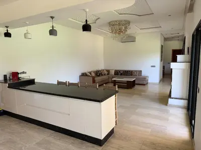a kitchen and living room with a counter and a couch at Villa Denalya in Marrakech