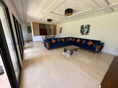 a living room with a blue couch and a table at Villa Denalya in Marrakech
