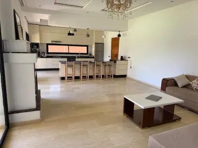 a living room with a couch and a table and a kitchen at Villa Denalya in Marrakech