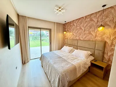 a bedroom with a large bed and a window at Appartement prestigia saphir in Oulad Akkou