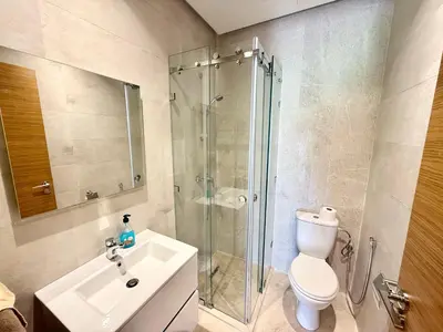 a bathroom with a shower and a toilet and a sink at Appartement prestigia saphir in Oulad Akkou
