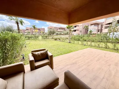 a living room with a couch and a view of a yard at Appartement prestigia saphir in Oulad Akkou