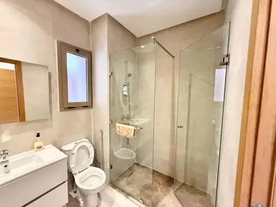 a bathroom with a shower and a toilet and a sink at Appartement prestigia saphir in Oulad Akkou