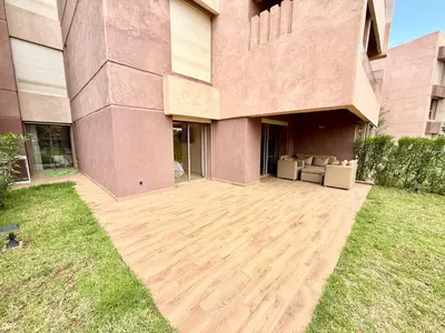 a house with a wooden patio in front of it at Appartement prestigia saphir in Oulad Akkou