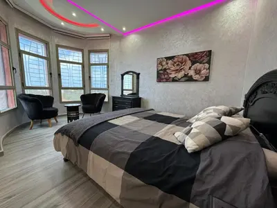 a bedroom with a large bed and a purple light at Villa piscine espace vert luxueuse in Oulad Akkou