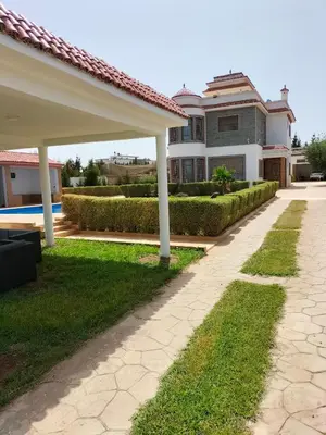 a walkway in front of a house at Villa piscine espace vert luxueuse in Oulad Akkou