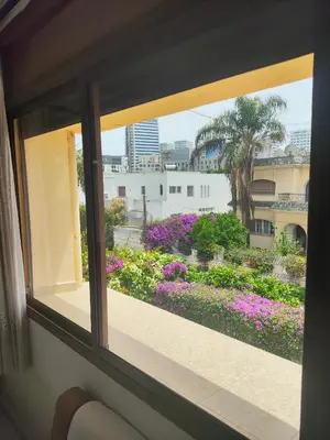 a window view of a garden with purple flowers at No21 Loulan Villa21\u53f7\u522b\u5885\u6c11\u5bbf in Oulad Akkou