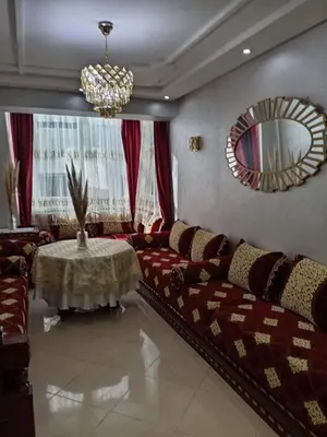 a living room with a couch and a table and a mirror at Soyer les biens venus in Oulad Akkou