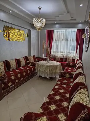 a living room with couches and a table at Soyer les biens venus in Oulad Akkou