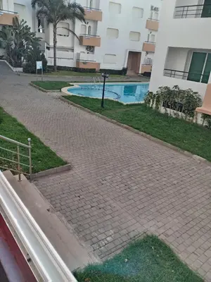 a brick walkway next to a building with a swimming pool at Soyer les biens venus in Oulad Akkou