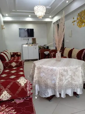 a room with a table and chairs and a tv at Soyer les biens venus in Oulad Akkou
