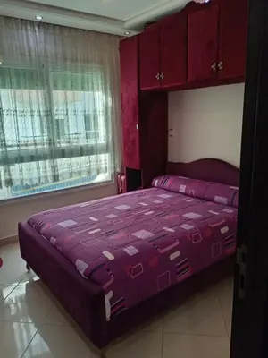 a bedroom with a purple bed with red cabinets at Soyer les biens venus in Oulad Akkou