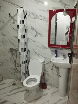 a bathroom with a toilet and a sink and a mirror at L'airoport in Oulad Tayeb