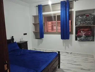 a bedroom with a blue bed and blue curtains at L'airoport in Oulad Tayeb