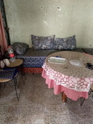 a room with a couch with a table and chairs at la maison du belmokhtar Mansour in Douar Sidi Mohammed