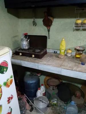 a kitchen counter with a stove and some pots and pans at la maison du belmokhtar Mansour in Douar Sidi Mohammed