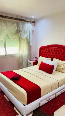 a bedroom with a large bed with a red headboard at Appartement de luxe à louer à la journée à Tanger Au centre ville in Fès