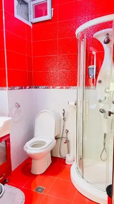 a red bathroom with a toilet and a shower at Appartement de luxe à louer à la journée à Tanger Au centre ville in Fès
