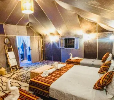 a room with two beds with swans on it at Sahara haven camp in Merzouga