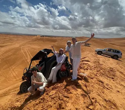 a group of people standing in the desert at Sahara haven camp in Merzouga