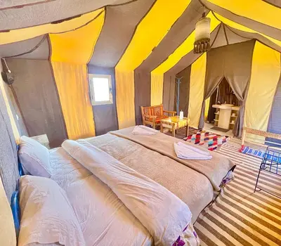 a bedroom with a large bed in a tent at Sahara haven camp in Merzouga