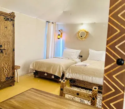 a room with two beds and a mirror at Sahara haven camp in Merzouga