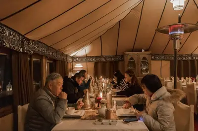 a group of people sitting at a table in a restaurant at Nourland Luxury Camp in Merzouga
