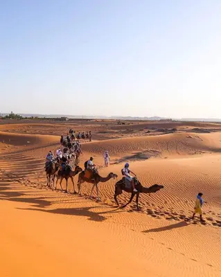 a group of people riding horses in the desert at Nourland Luxury Camp in Merzouga
