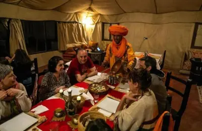 a group of people sitting around a table in a tent at Nourland Luxury Camp in Merzouga