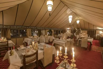 an overhead view of a restaurant with white tables and candles at Nourland Luxury Camp in Merzouga