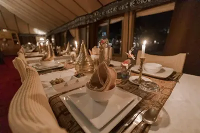 a long table with a plate of food and candles at Nourland Luxury Camp in Merzouga