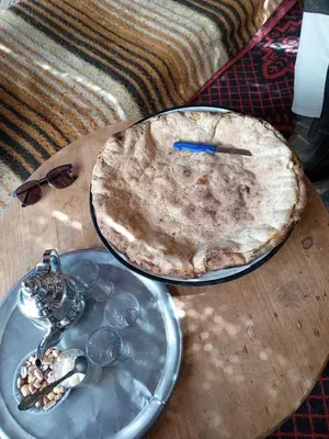 a pizza sitting on top of a wooden table at Villasaharamerzouga in Merzouga