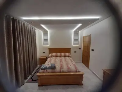 a bedroom with a large bed and curtains at diki in Oulad Akkou