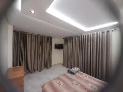 a bedroom with a bed and curtains and a television at diki in Oulad Akkou
