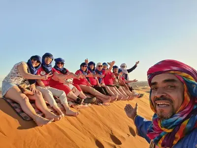 a group of people sitting in the desert at Bivouac Luxe Le Ciel Bleu in Hassilabied