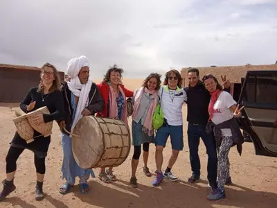 a group of people posing for a picture in the desert at Bivouac Luxe Le Ciel Bleu in Hassilabied