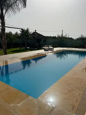 a swimming pool with blue water in a yard at Maison au calme avec piscine privé et arboré in Meknès