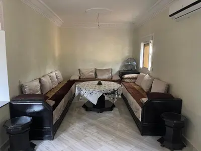 a living room with a couch and a table at Maison au calme avec piscine privé et arboré in Meknès