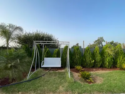a swing set in a garden with grass at Maison au calme avec piscine privé et arboré in Meknès