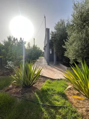 a building with plants in front of it at Maison au calme avec piscine privé et arboré in Meknès