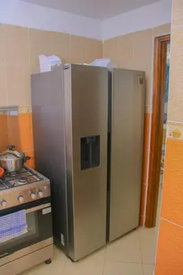 a stainless steel refrigerator next to a stove in a kitchen at Appartement du luxe in Oulad Akkou