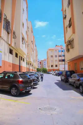 a street with cars parked in a parking lot at Appartement du luxe in Oulad Akkou