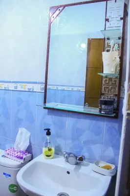 a bathroom with a sink and a mirror and a toilet at Appartement du luxe in Oulad Akkou