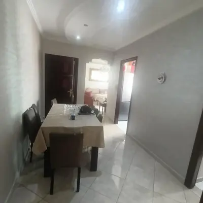a dining room with a table and chairs and a room at Res zin el mahabba in Oulad Akkou