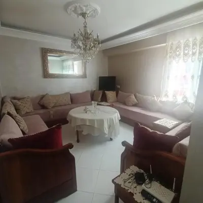a living room with a couch and a table at Res zin el mahabba in Oulad Akkou